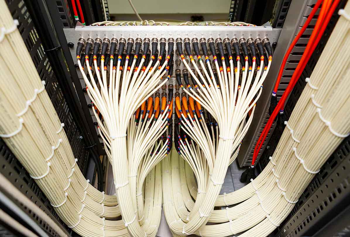 Close-up of well-structured, multi-colored network fibre cables, representing the orderly and efficient design of a structured cabling system