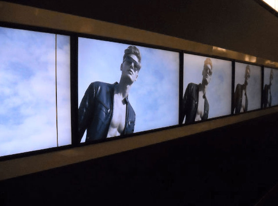 A digital sign featured a male model wearing shades against a blue sky, presenting digital signage installed by NTFS.